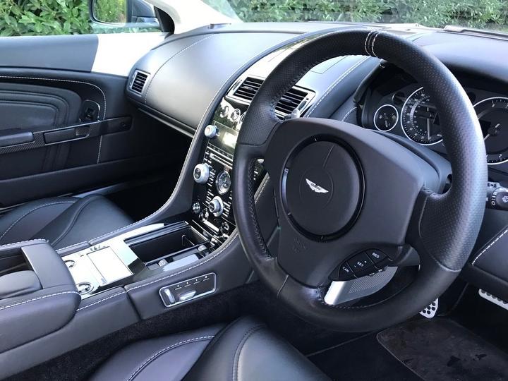Close-up of the luxurious Aston Martin DBS steering wheel and dashboard.