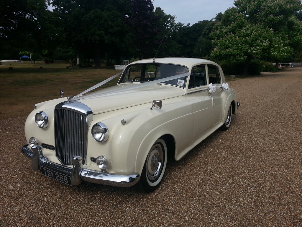 A classic white Bentley S1 available for rent, pictured outdoors