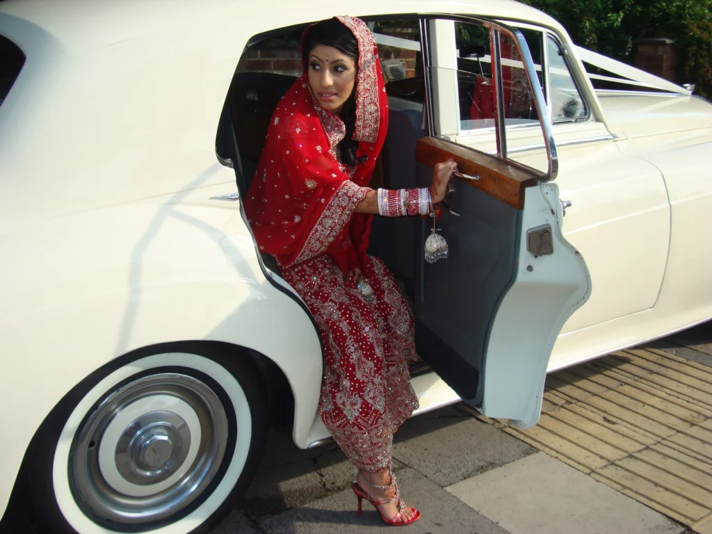 A classic 1956 Bentley S1 in white, parked in front of a stately building, available for hire