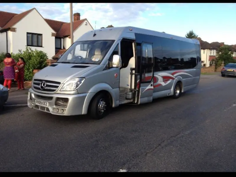 A professional chauffeur opening the door of a party bus.