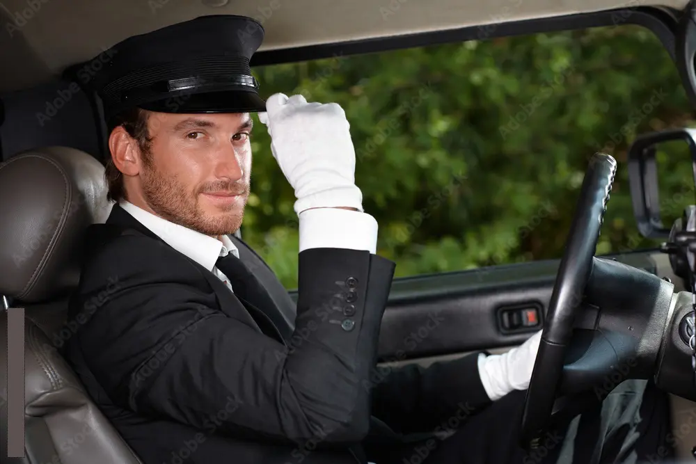 A chauffeur driving a luxury car through London at night